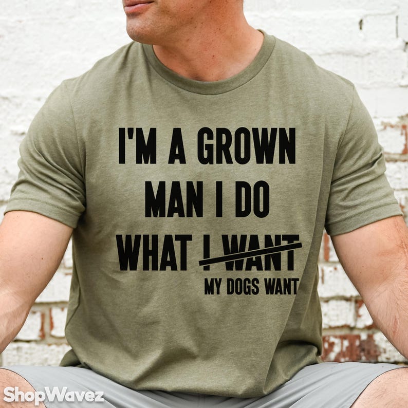 May include: A green t-shirt with the text "I'm a grown man I do what I want" with the word "want" crossed out and the text "My dogs want" written below.