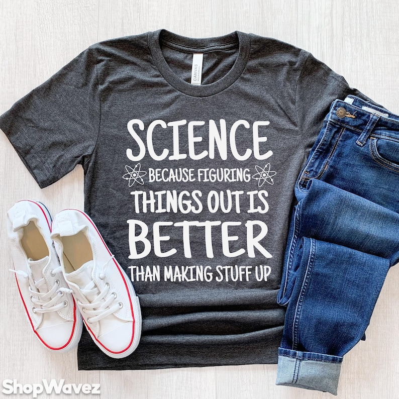 May include: A dark gray t-shirt with the text "SCIENCE because figuring things out is BETTER than making stuff up" in white. The shirt is decorated with two white atom symbols.
