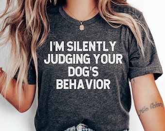 May include: A dark gray t-shirt with the text "I'm silently judging your dog's behavior" printed in white.