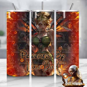 Puede incluir: Un vaso de acero inoxidable con un diseño de fantasía. El diseño presenta un hada rubia con cuernos y alas, sobre un fondo de fuego. El texto "Powered By Pixie Dust" se muestra en el vaso.