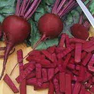 May include: Close-up of red beets, some whole and some chopped into sticks. The beets are on a wooden cutting board with a knife nearby.