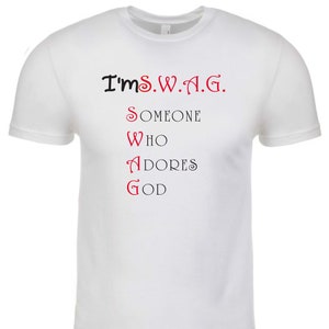 Op de afbeelding: Wit T-shirt met zwarte tekst die "I'm S.W.A.G." luidt en rode tekst die "SOMEONE WHO ADORES GOD" luidt.
