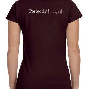 May include: A maroon t-shirt with the text "Perfectly Flawed" and "Luke 6:42" printed on the back.