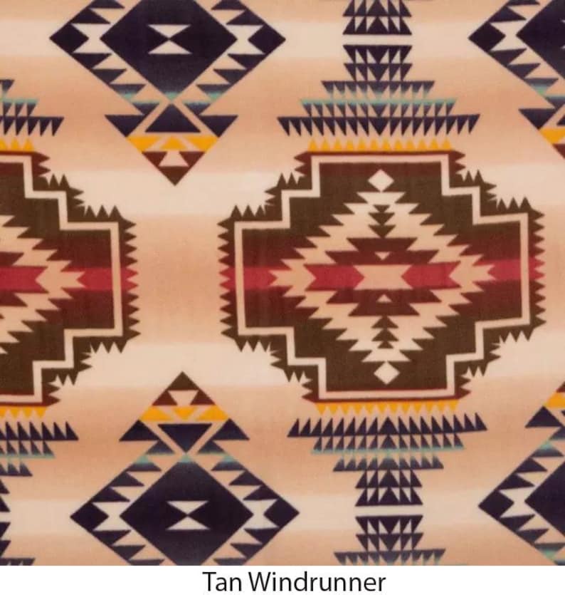 Puede incluir: Manta de forro polar con estampado marr&oacute;n y beige con un dise&ntilde;o geom&eacute;trico. La manta tiene un fondo beige con formas geom&eacute;tricas marrones, rojas y azules. El texto "Tan Windrunner" est&aacute; en la parte inferior de la imagen.