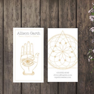 Puede incluir: Dos tarjetas de visita con texto dorado e ilustraciones. La primera tarjeta presenta una mano con un ojo en la palma y el texto "Allison Garth Tarot / Mystic / Healer". La segunda tarjeta presenta un diseño geométrico con un círculo y un triángulo y el texto "410.852.4646 Allison@mystic.com mystorereader.com".