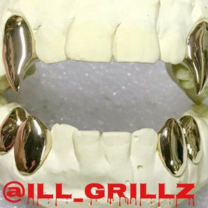 May include: Gold teeth grillz with a pointed fang design. The grillz are displayed on a white mold of a mouth. The text "@ill_grillz" is visible at the bottom of the image.