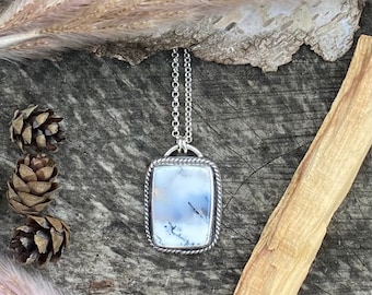 May include: A silver chain necklace with a rectangular pendant featuring a cloudy white agate stone set in a silver frame.