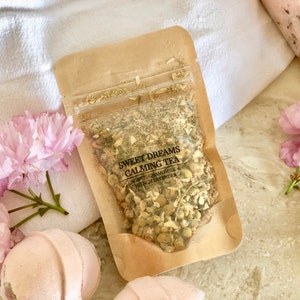 May include: A brown paper pouch filled with dried herbs labeled "Sweet Dreams Calming Tea" with the ingredients listed as "Organic Chamomile & French Lavender".