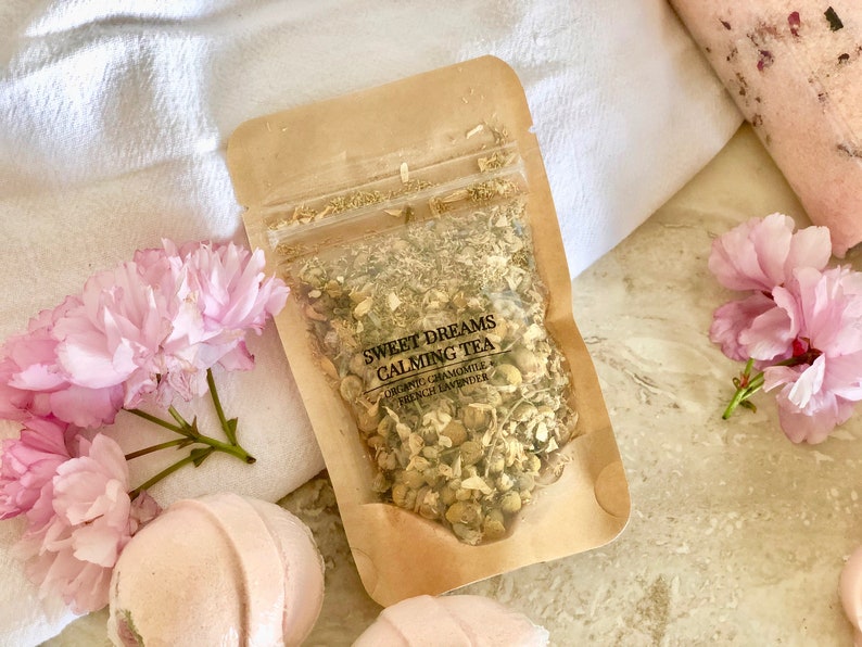 May include: A brown paper pouch filled with dried herbs labeled "Sweet Dreams Calming Tea" with the ingredients listed as "Organic Chamomile & French Lavender".