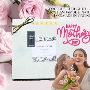 May include: A gift box tied with a gold ribbon, with the text "Happy Mother's Day." The box has a label that reads "Herbs & Twine." Pink roses and a woman and child are in the background.