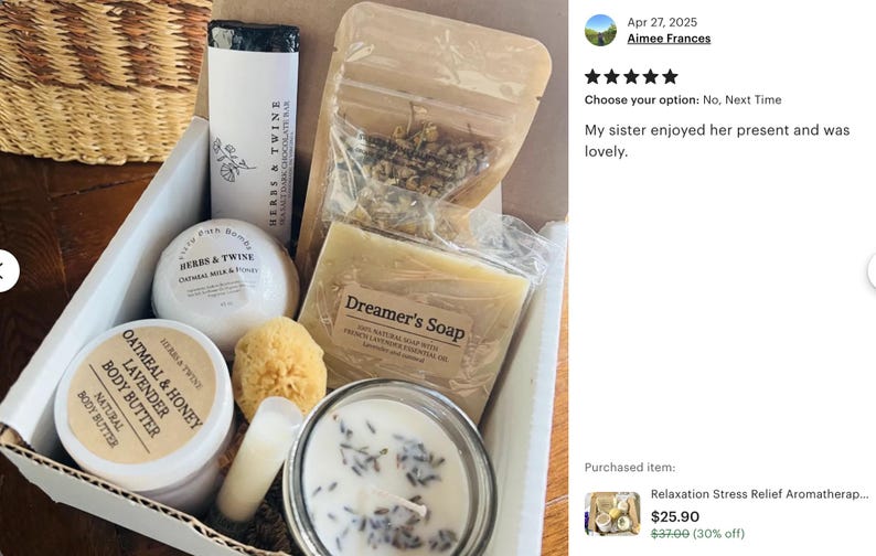 May include: A gift box filled with relaxation items. It includes a bar of dark chocolate, a bath bomb, a jar of body butter, a natural soap bar, a candle, a loofah, and a bag of dried herbs. The box is white with a brown interior.