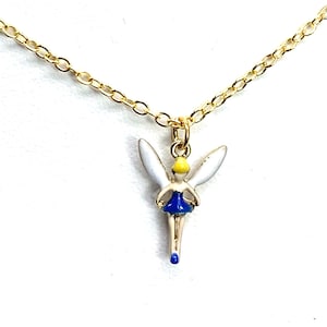 May include: A gold chain necklace with a charm of a fairy with white wings, a yellow head, a blue dress, and blue shoes.