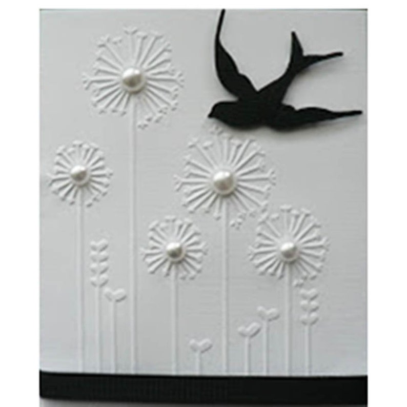 May include: White card with embossed dandelions and pearl accents. A black silhouette of a swallow is in flight. The dandelions have pearl centers and are arranged with small leaf and heart details. A black ribbon is at the bottom.
