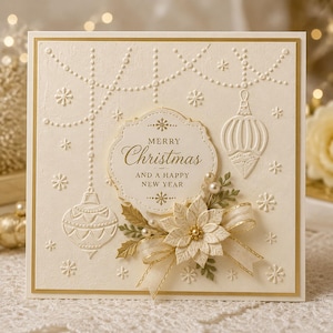 May include: A square cream-colored greeting card featuring embossed hanging ornaments, snowflakes, and a central scalloped label with the gold text Merry Christmas and a Happy New Year. A fabric poinsettia, ribbon, and small pearls decorate the bottom.