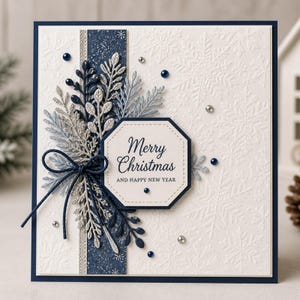 Puede incluir: Una tarjeta de felicitación cuadrada con fondo blanco de copos de nieve en relieve, con una franja vertical azul oscuro, follaje troquelado plateado y azul marino, un lazo de cuerda azul marino y una etiqueta octogonal con Merry Christmas.