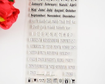 May include: Clear plastic sheet with black text and icons. The text includes numbers, months of the year, days of the week, and words like "urgent", "remember", "important", "workout", "film", "post", "wish", "list", "notes", "buy", "review", "holiday", "call", "date", "night", "blog", "party", "don't forget", "no", "school", "home", "date", and "email". The icons include a gas pump, a heart, glasses, an envelope, a fork and knife, a snowflake, a gift box, and a shopping cart.