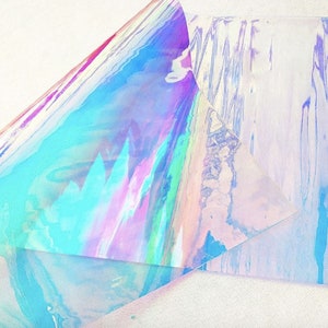 Pu&ograve; includere: Materiale olografico iridescente con uno spettro di colori tra cui blu, rosa e verde. Il materiale &egrave; stratificato, creando un senso di profondit&agrave; e dimensione. L'effetto complessivo &egrave; scintillante ed etereo.
