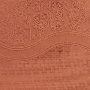 Op de afbeelding: Vierkant terracotta-kleurig papier met een reli&euml;f bloemenontwerp. Het bovenste gedeelte heeft rozen en bladeren, terwijl de onderkant een geweven mandpatroon heeft. Een decoratieve rand scheidt de twee secties.