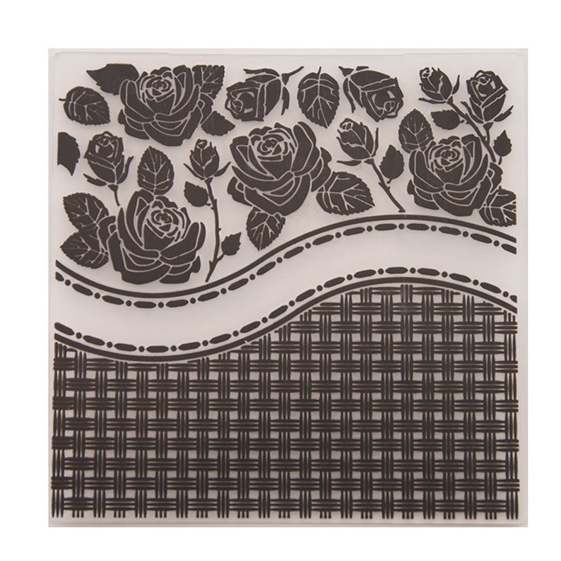 Op de afbeelding: Een doorzichtige, vierkante embossing folder met een bloemenrozenontwerp en een geweven mandpatroon. De rozen zijn gedetailleerd met bladeren en stelen, en het mandenpatroon bevindt zich in de onderste helft. Knutselgereedschap.