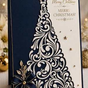 Könnte beinhalten: Eine marineblaue und cremefarbene Grußkarte mit einem ausgestanzten Weihnachtsbaum mit komplizierten Schnörkelmustern. Die Karte enthält den goldgeprägten Text Merry Christmas, eine marineblaue Schleife mit goldenen Akzenten sowie kleine goldene Sterne.