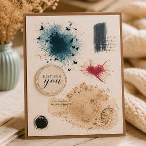 Può includere: Biglietto di auguri fatto a mano con sfondo beige e bordo marrone. La carta presenta schizzi di acquerello in blu, marrone e rosso, insieme a piccole illustrazioni di farfalle nere. Il testo "JUST FOR you" è in un design circolare.