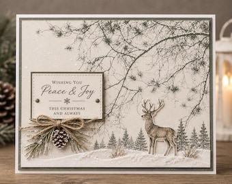 May include: A rectangular Christmas greeting card featuring a beige background with a dark gray pine tree branch illustration, a standing deer, and a forest silhouette. A label reads: Wishing You Peace & Joy This Christmas And Always, with a pinecone.