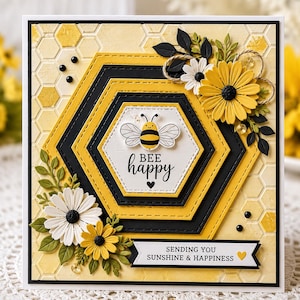 Puede incluir: Una tarjeta de felicitación cuadrada con fondo de panal amarillo, con un diseño hexagonal central en capas. Una ilustración de abeja se sitúa sobre el texto "BEE happy" con un corazón. Los detalles florales incluyen margaritas amarillas y blancas.