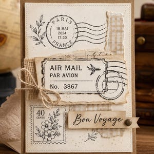 Puede incluir: Una tarjeta de felicitación con temática de viajes, fondo color crema, sello postal de París, etiqueta de correo aéreo, sello floral de 40 centavos y etiqueta de Bon Voyage. La tarjeta incluye un lazo de arpillera y bordes de papel rasgados.