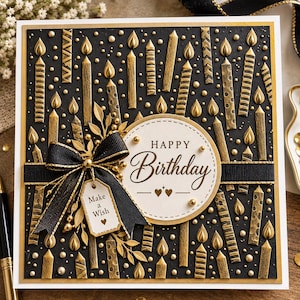 Könnte beinhalten: Eine quadratische Grußkarte mit schwarzem Hintergrund, verziert mit geprägten goldenen Kerzen und Punkten. Ein weißer Kreis in der Mitte zeigt den Text "HAPPY Birthday" mit zwei kleinen Herzen. Eine schwarze Schleife hält ein "Make a Wish"-Schild.
