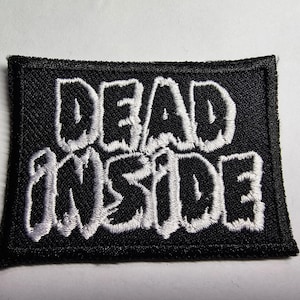 May include: Black fabric patch with white embroidered text that reads "DEAD INSIDE".