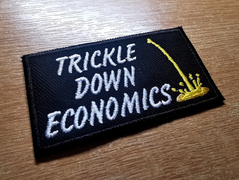 May include: Black embroidered patch with white text that reads "Trickle Down Economics" and a yellow graphic of a dripping faucet.