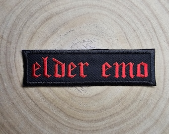 May include: Black embroidered patch with the words "elder emo" in red lettering.