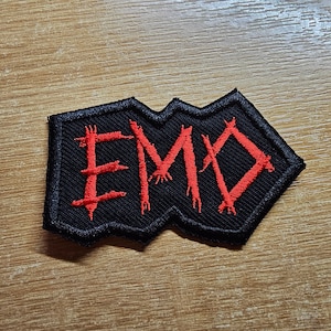 May include: Black fabric patch with the word "EMO" embroidered in red thread.