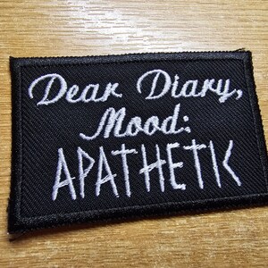 Può includere: Toppa ricamata nera con testo bianco che recita "Caro diario, umore: APATICO".