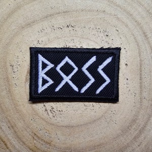 May include: Black fabric patch with white embroidered runes spelling "BOSS".