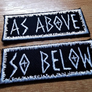 May include: Two black embroidered patches with white stitching. The top patch reads "AS ABOVE" and the bottom patch reads "SO BELOW".
