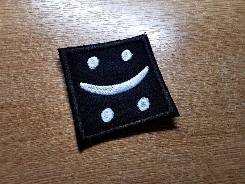 May include: Black fabric patch with a white embroidered smiley face.