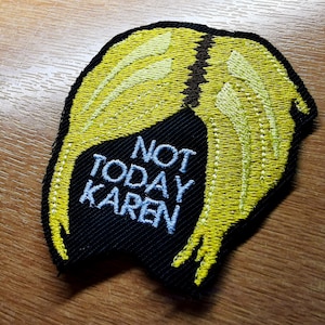 May include: A black and yellow embroidered patch with the text "Not Today Karen" in white lettering.