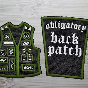 May include: A black and green embroidered vest with various patches, including a snake, a skull, and a cross. A separate black and green patch reads "obligatory back patch".