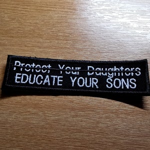 May include: Black embroidered patch with white text that reads "Protect Your Daughters Educate Your Sons".
