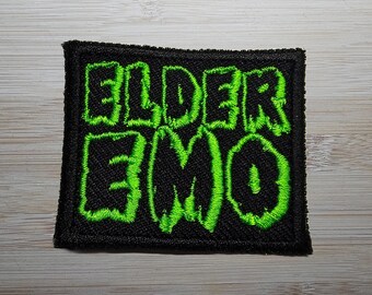 May include: Green embroidered patch with the words "Elder Emo" on a black background.