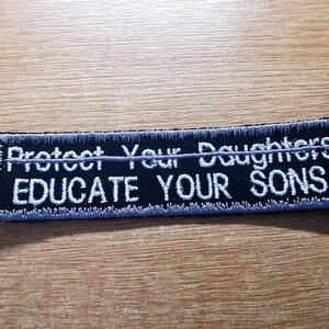 May include: Black embroidered patch with white text that reads "Protect Your Daughters Educate Your Sons".