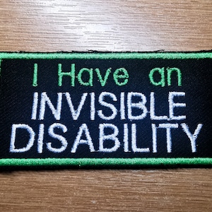 May include: A black and green embroidered patch with white text that reads "I Have an Invisible Disability".