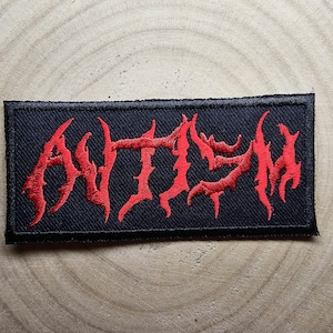 May include: A black patch with red embroidered lettering that reads "ANTHEM".