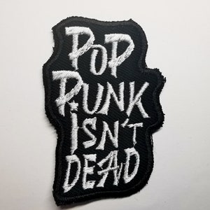 May include: Black embroidered patch with white text that reads "Pop Punk Isn't Dead".