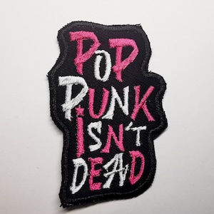 May include: Black embroidered patch with the text "Pop Punk Isn't Dead" in pink and white lettering.