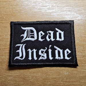 May include: Black embroidered patch with white lettering that reads "Dead Inside".