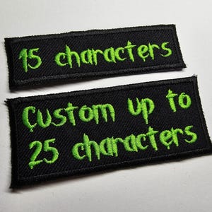 May include: Two black fabric patches with green embroidered text. The top patch says "15 characters". The bottom patch says "Custom up to 25 characters".