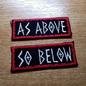 May include: Two black embroidered patches with red borders. The top patch says "AS ABOVE" in white lettering. The bottom patch says "SO BELOW" in white lettering.