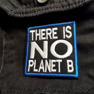 以下が含まれることがあります： 青いステッチと白い文字で「There is No Planet B」と書かれた黒いパッチです。